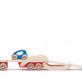 Bajo eco-friendly wooden auto transporter lorry with its trailer lowered and two blue cars driving up on a white background