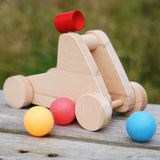 bajo catapult toy sitting on a wooden bench with balls around it
