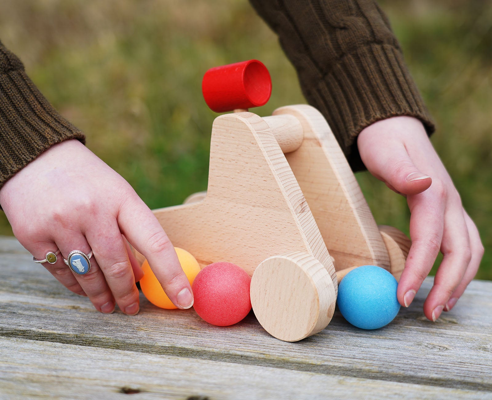 hands holding the bajo wooden catapult toy