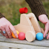 hands holding the bajo wooden catapult toy