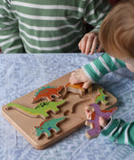 Bajo Wooden Dinosaur Puzzle with 6 colourful figures. Children placing the figures into the shaped slots on the base.