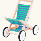 Bajo wooden doll stroller toy with a blue and green stripe cotton seat and shelf, white wooden wheels with black rubber trims. 