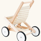 Back of the Bajo wooden doll stroller toy with a cream and natural stripe cotton seat and shelf, white wooden wheels with black rubber trims. 