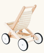 Back of the Bajo wooden doll stroller toy with a cream and natural stripe cotton seat and shelf, white wooden wheels with black rubber trims. 