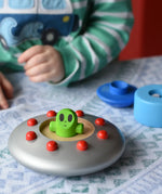 Child playing with the Bajo Alien Flying Saucer, with the top two pieces taken off. 