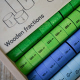 Thick wooden disks showing the fraction value from the the Bajo fractions set inside the storage box