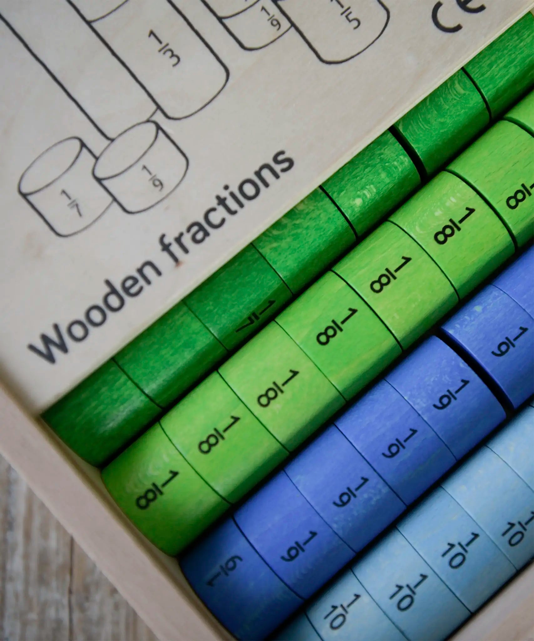 Thick wooden disks showing the fraction value from the the Bajo fractions set inside the storage box