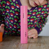 A child looking at the the two half fraction blocks from the Bajo Fractions Set. A set of coloured wooden blocks marked with fractions on each block. These heirloom quality toys by Bajo are part of a wide range of wooden toys available here at Babipur.
