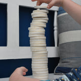 A close up of a child's hand stacking the wooden dics from a Bajo Memory Game on top of each other. These heirloom quality toys by Bajo are part of a wide range of wooden toys available here at Babipur.