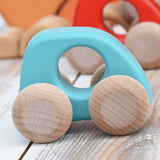 A Bajo handmade wooden light blue mini car available at Babipur. Features unpainted wheels and a cut out hole for a easy hold. Photo is in a playroom setting