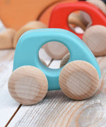 A Bajo handmade wooden light blue mini car available at Babipur. Features unpainted wheels and a cut out hole for a easy hold. Photo is in a playroom setting