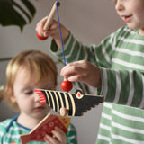 Bajo magnetic fishing game toy. Child holding wooden rod with black fish attached.