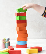 A person stacking the Bajo Rainbow Blocks on top of each other making a horizontal stack