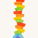 Bajo handmade wooden rainbow block toys stacked in a tower on a white background