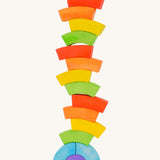 Bajo handmade wooden rainbow block toys stacked in a tower on a white background