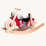 Bajo wooden rocking motorcycle toy with a natural light wood finish, red body panels, a black seat, and silver engine details.