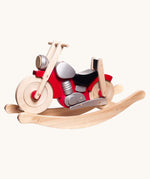 Bajo wooden rocking motorcycle toy with a natural light wood finish, red body panels, a black seat, and silver engine details.