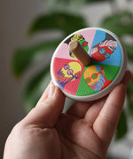 Bajo Pop Art Mr Bajor Spinning Top in an adult's hand showing the design on the top.