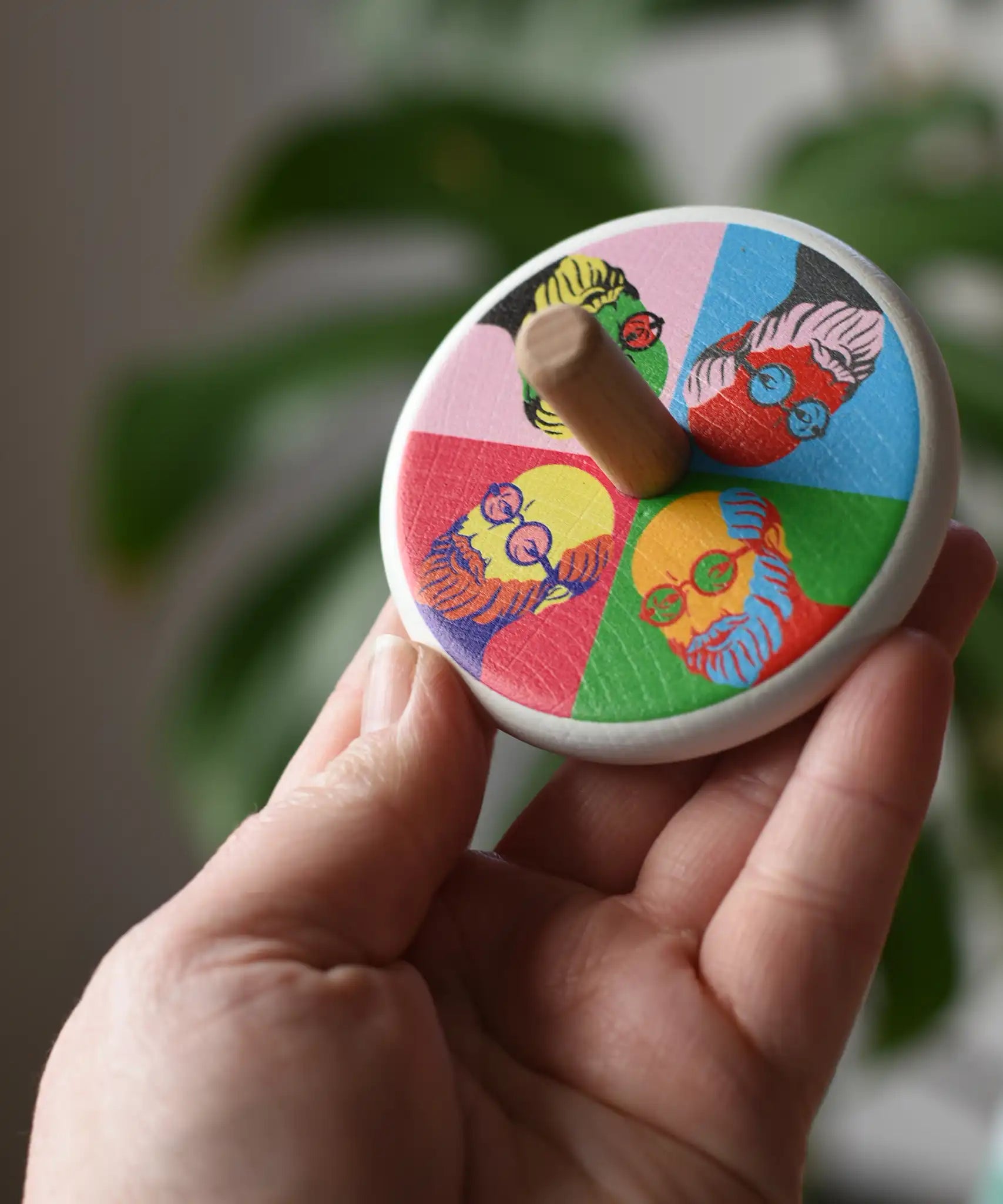 Bajo Pop Art Mr Bajor Spinning Top in an adult's hand showing the design on the top.