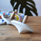 Side of a Bajo wooden spinning top placed on a wooden surface.