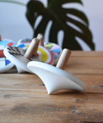Side of a Bajo wooden spinning top placed on a wooden surface.