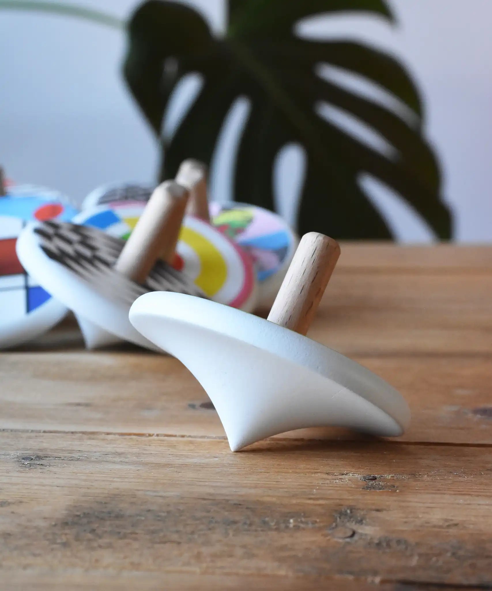 Side of a Bajo wooden spinning top placed on a wooden surface.