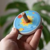 Bajo Universe Spinning Top in an adult's hand.