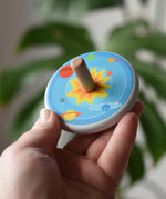 Bajo Universe Spinning Top in an adult's hand.
