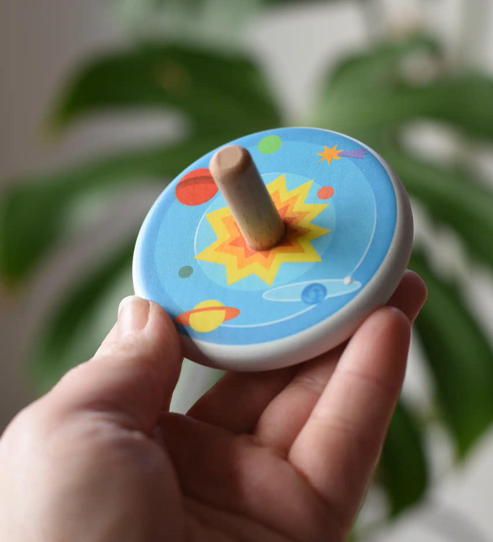 Bajo Universe Spinning Top in an adult's hand.