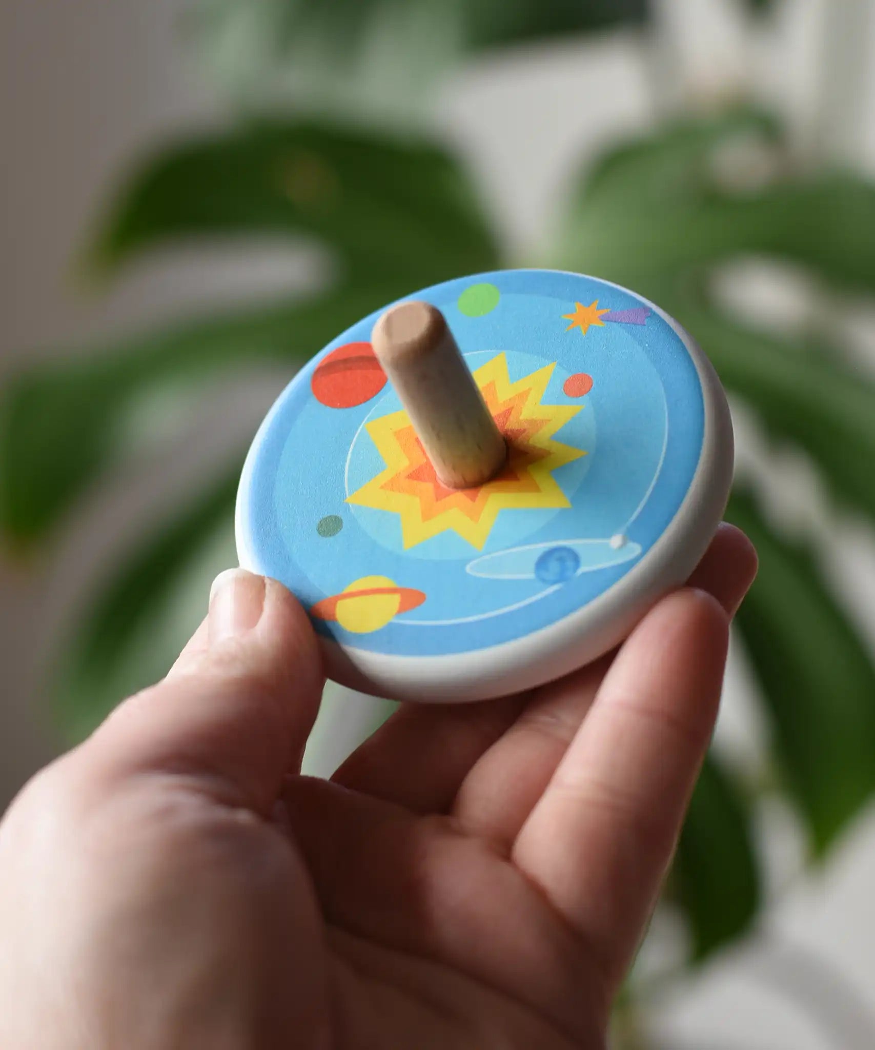 Bajo Universe Spinning Top in an adult's hand.