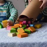 Bajo 43 wooden building blocks. 43 blocks, in 16 different shapes and 10 colours. Child tipping blocks from the sturdy cylinder shaped storage box.
