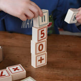 A child stacking up blocks from the Bajo 40 Numbers & Symbols Blocks set on top of each other. These heirloom quality toys by Bajo are part of a wide range of wooden toys available here at Babipur. 