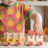 Child putting the red removable roof piece on the Bajo train carriage