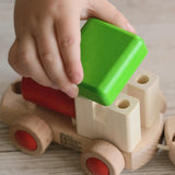 Child putting the green removable roof piece on the Bajo train