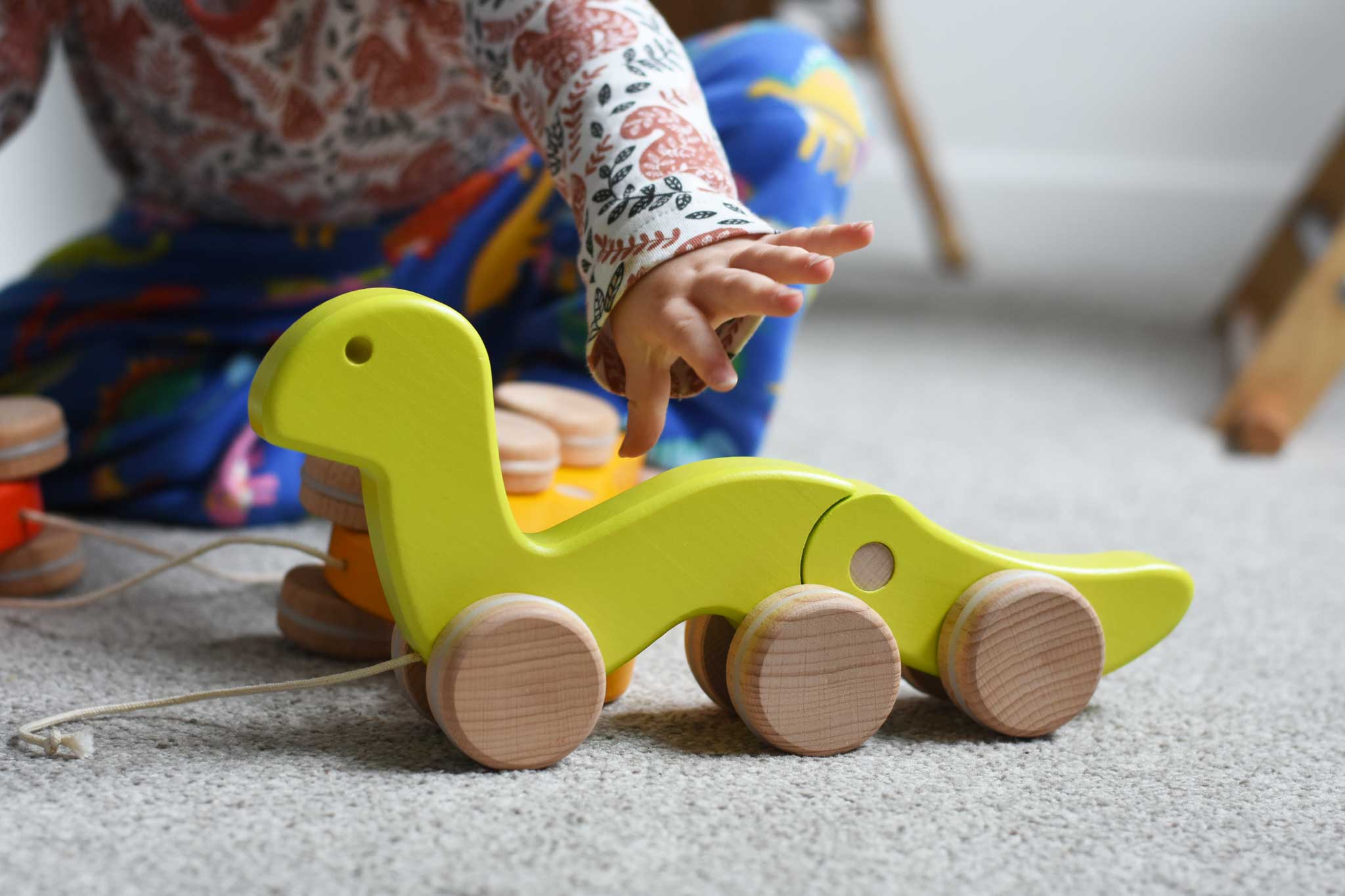 A child reaching for a green Bajo wriggling worm pull along toy. These heirloom quality toys by Bajo are part of a wide range of wooden toys available here at Babipur. 