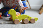 A child reaching for a green Bajo wriggling worm pull along toy. These heirloom quality toys by Bajo are part of a wide range of wooden toys available here at Babipur. 