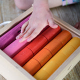 Bajo Fraction Set Maths Resource Learning Toy showing child's hand over the fraction blocks in a wooden box