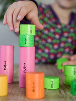 Bajo Fraction Set Maths Resource Learning Toy showing child's hand playing with the fraction blocks on a wooden table