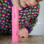 Bajo Fraction Set Maths Resource Learning Toy showing child looking and playing with two 1/2 fraction blocks on a wooden table