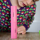 Bajo Fraction Set Maths Resource Learning Toy showing child looking and playing with two 1/2 fraction blocks on a wooden table