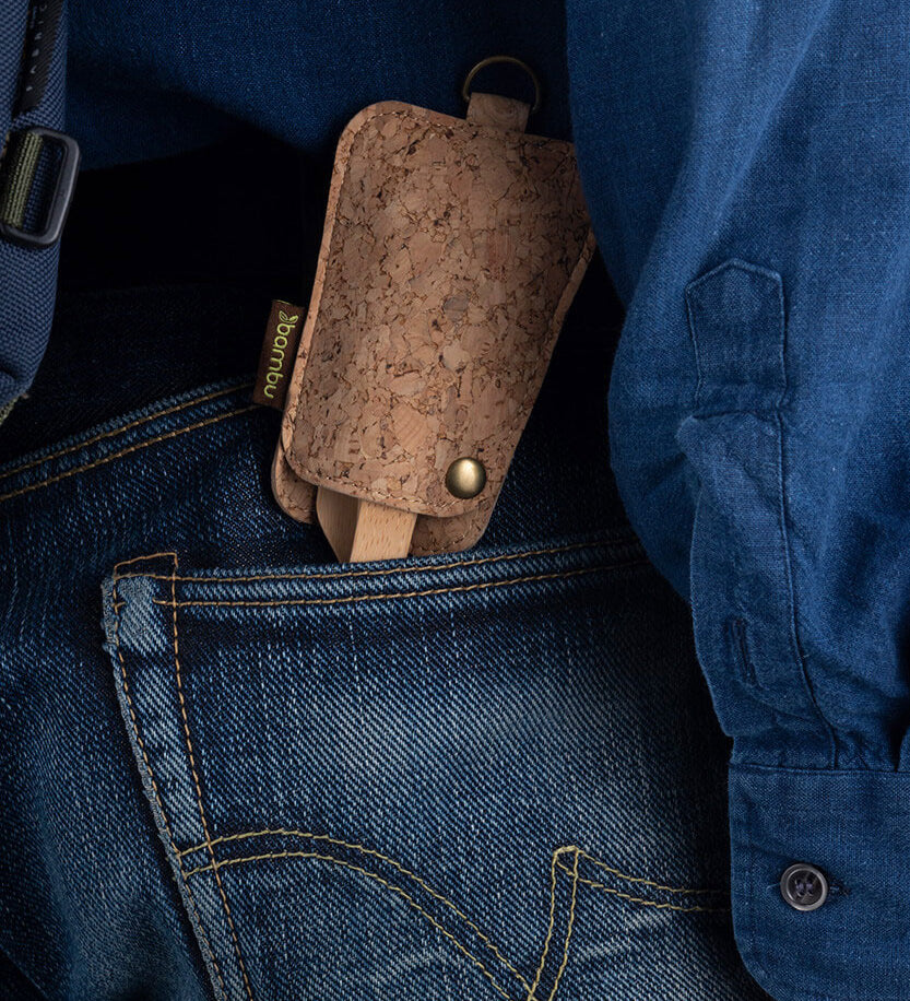 The Bambu Bamboo Utensil Travel Set with Cork Fabric Pouch shown in a person's back pocket of a pair of denim jeans