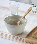 A Bambu Serving Spoon placed in an empty ceramic bowl.