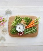 A top down view of the large Bumbu bamboo serving and cutting board with various foods on top 
