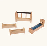 Beck Holzspielzeug wooden barn accessories including feeding manger, two feeding troughs, blue water trough with pump, and natural wood farm pieces.