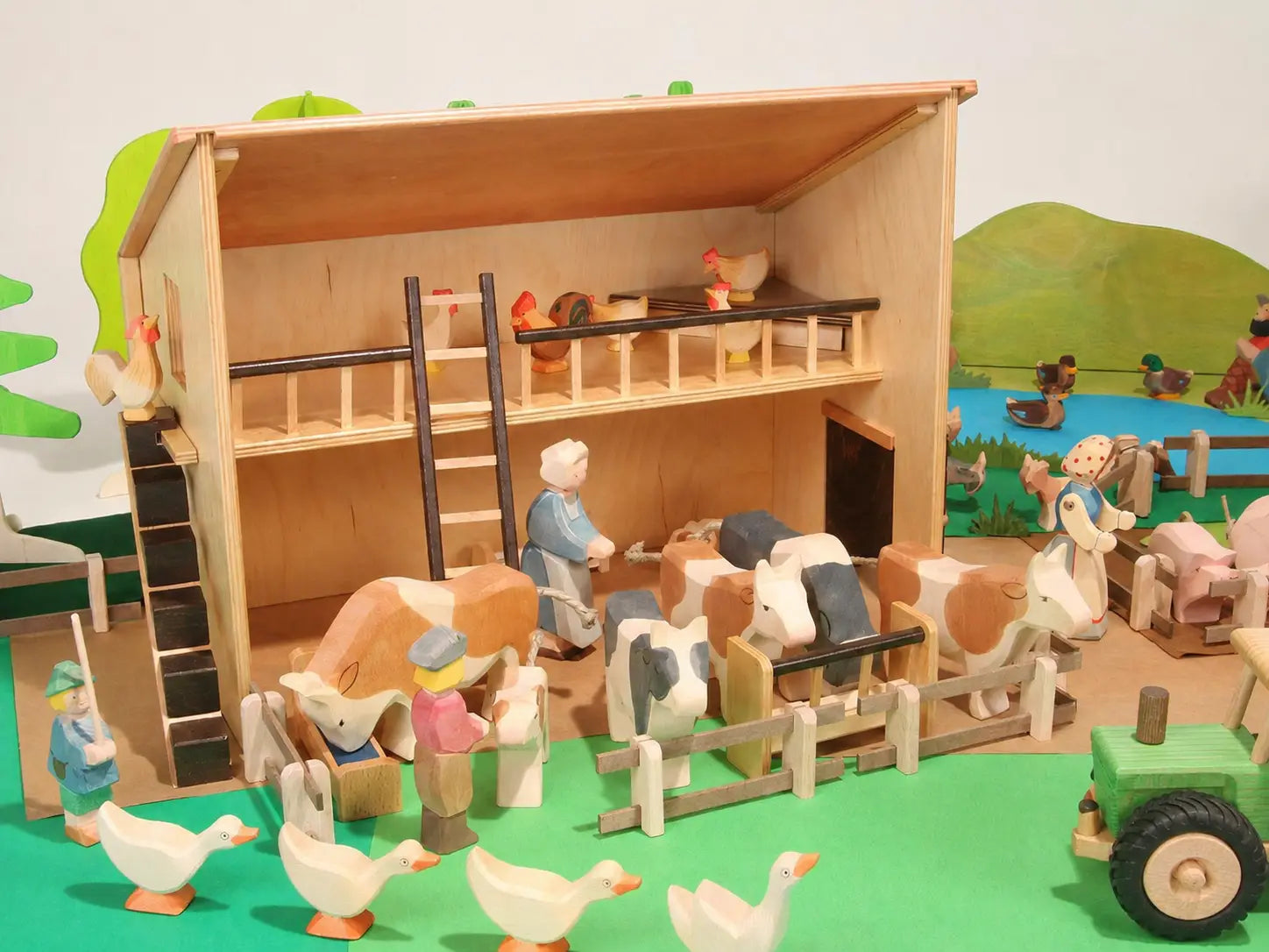 Beck Holzspielzeug large wooden farm barn filled with Ostheimer wooden farm animal and people figures in an imaginative small-world play scene.