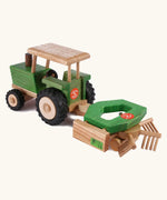 Beck Holzspielzeug wooden toy tractor pulling hay tedder attachment toy for realistic small-world farm play.