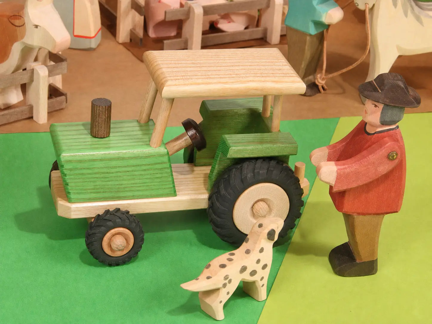 Beck Holzspielzeug traditional wooden toy tractor in small-world farm play scene with Ostheimer people and animal figures.
