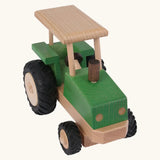 Front angled view of Beck Holzspielzeug steerable wooden toy tractor with hand carved detail and large chunky rubber wheels for farm play.