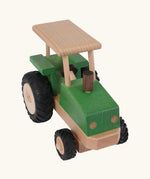 Front angled view of Beck Holzspielzeug steerable wooden toy tractor with hand carved detail and large chunky rubber wheels for farm play.
