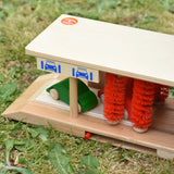 Beck wooden toy car wash with two toy cars placed inside.